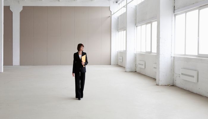 Businesswoman walking through empty office premises considering a purchase