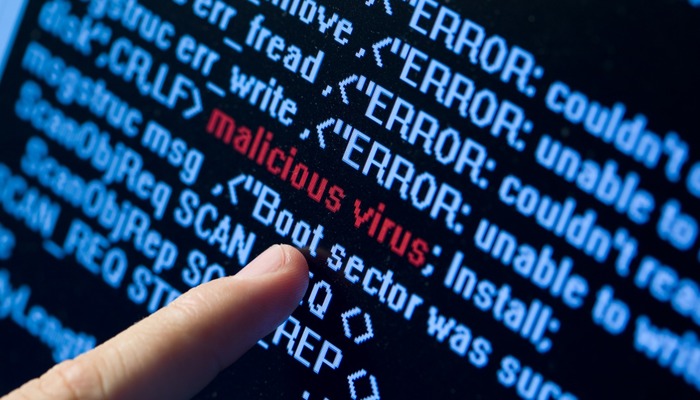 Person pointing at lines of code on a computer screen