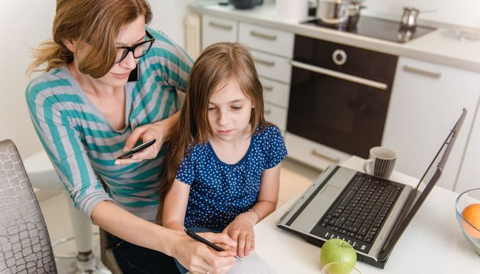 Mother working on her business at home with her daughter