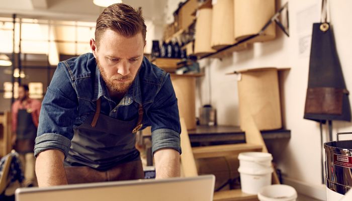 Man in work space using laptop