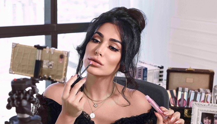 Huda Kattan, founder of Huda Beauty applying lipstick