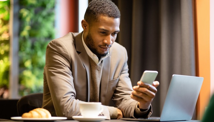 Man reading email on his phone at a coffee shop