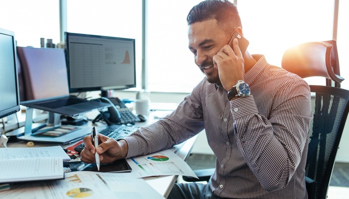 Accountant on phone in office while looking at chart