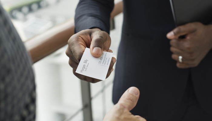 Closeup of businessman giving his business card to another businessman