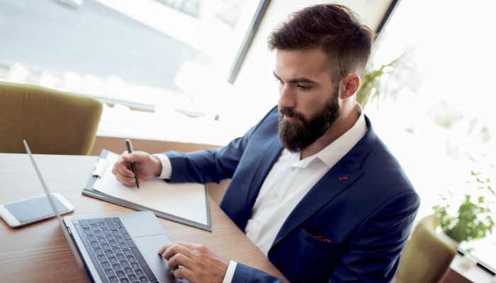 A young businessman sitting at a desk and working on his laptop